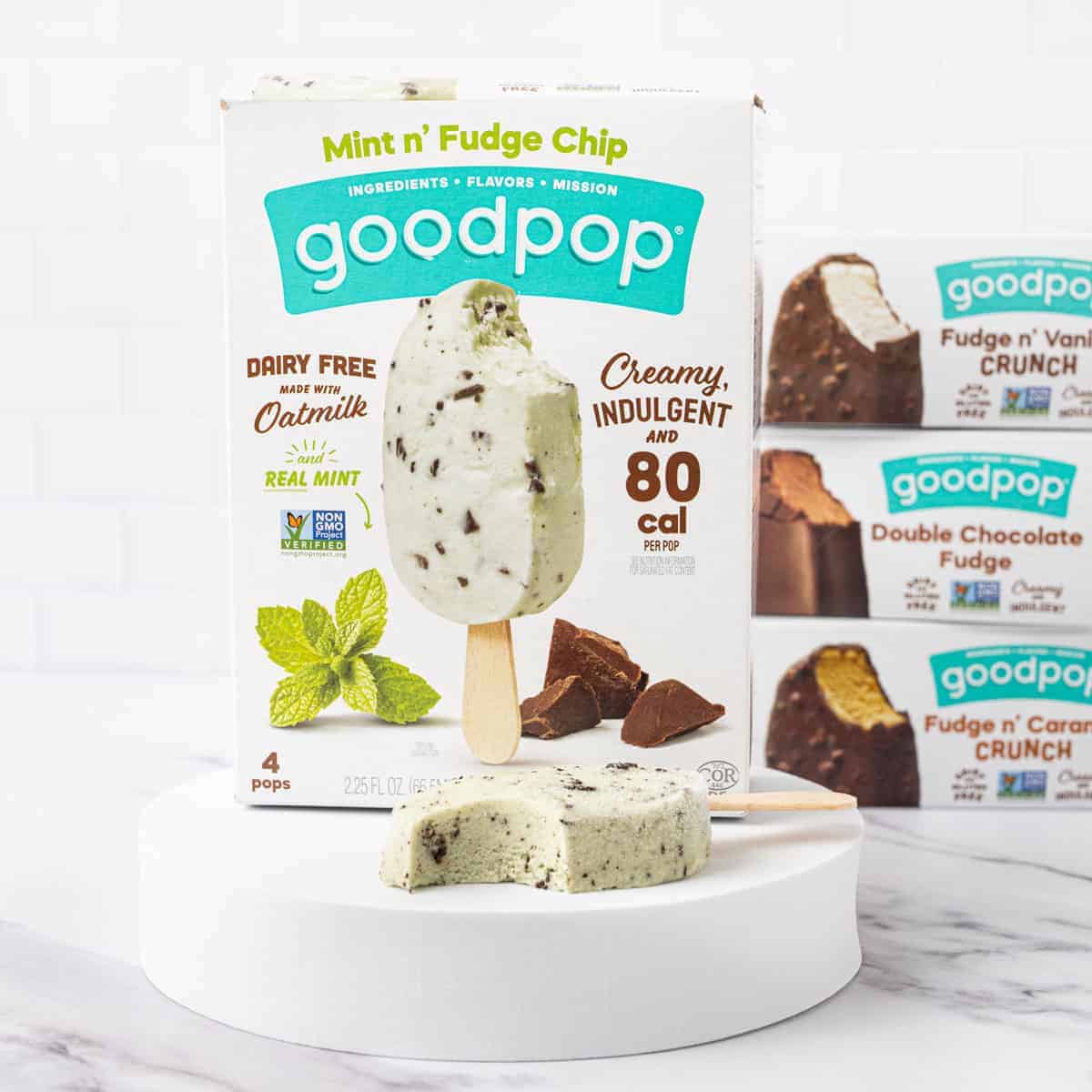 A box of GoodPop's Mint n' Fudge Chip dipped bars with a popsicle in front of it with a bite taken out.