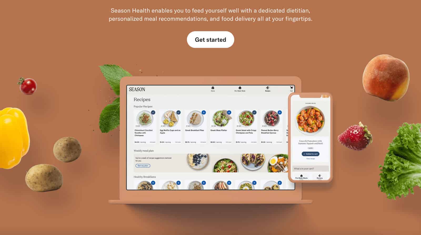 An image of a website header showing a laptop with multiple recipes for the customer to choose from. Fruits and vegetables are shown off the screen.